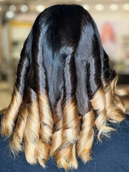 A different styling of the ombre hair, with tighter, more defined curls that create a bouncy and voluminous look.