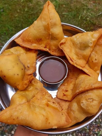 You can't go wrong with classic, hot samosas. Mine have a crispy, flaky pastry and are filled with a spiced potato and pea mixture, served with a tangy tamarind chutney for dipping.