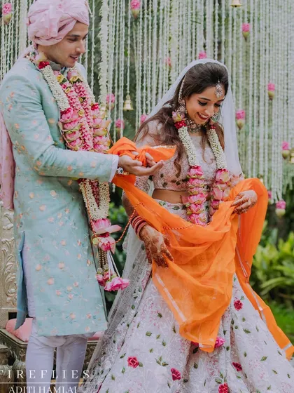 A happy, candid moment from Jenita and Vinit's wedding ceremony. The backdrop of hanging rajnigandha from the 'Tree of Love' mandap adds a delicate and traditional touch.