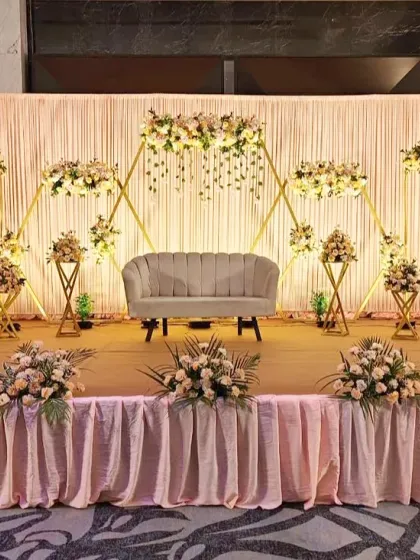 This engagement stage design is modern and minimalist. We used a series of interconnected golden hexagonal frames decorated with delicate pastel flowers. The simple, clean lines create a sophisticated and stylish backdrop for the couple.