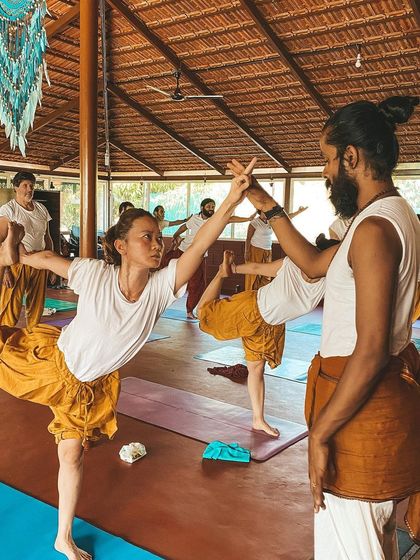 I provide a hands-on assist in Dancer's Pose, helping a student find their balance and open their heart. This personal guidance is a cornerstone of our teacher training program.