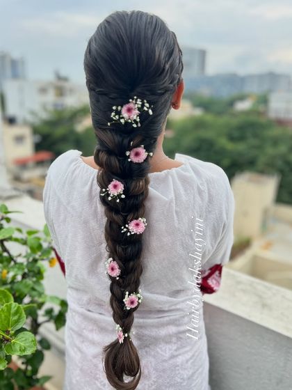 A still image of the pull-through braid with delicate pink flowers, perfect for a daytime event.
