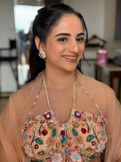 A smiling portrait of the bride, showing off her unique green eyeliner. The rest of the makeup is kept soft and peachy to balance the look.