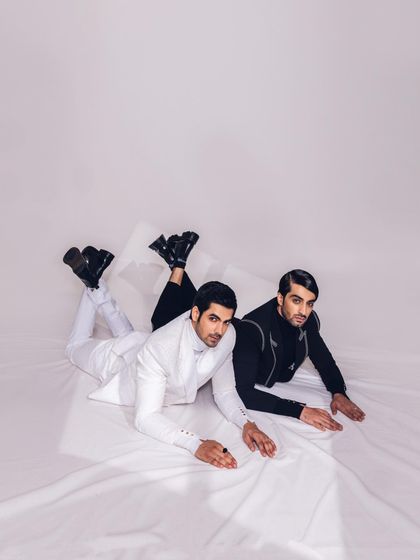 A similar overhead shot with the models looking towards the camera. This styling choice creates a direct and engaging image while highlighting the clean lines of the modern suits.