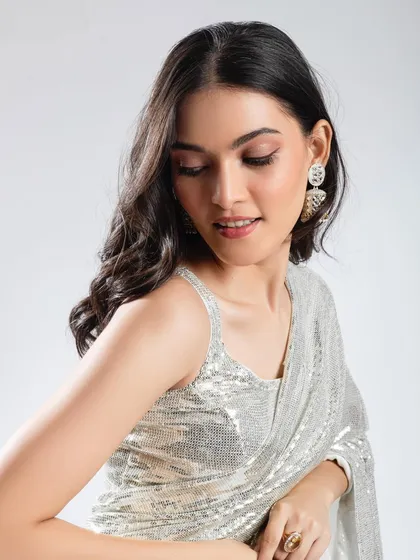 A soft glam look with a focus on shimmer. The eye makeup uses soft, glittering tones, paired with dewy skin and soft curls for a glamorous party or reception look.