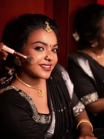 A behind-the-scenes shot of me applying finishing powder. The model is smiling, happy with the progress of her traditional makeover.