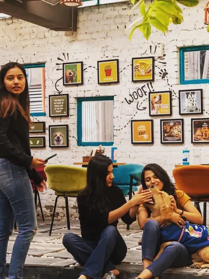A group of friends relaxing with their dog against our cool wall of art. It's the perfect hangout spot.