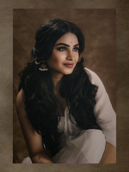 A beautiful portrait with an artistic frame, focusing on the model's expressive face and voluminous hair. The warm tones give this image a vintage feel.