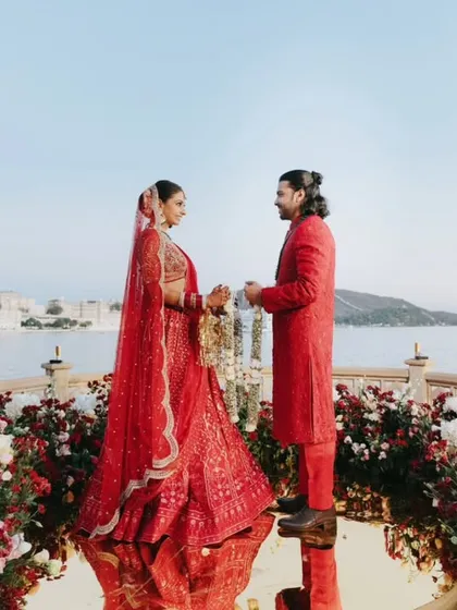 A couple exchanges varmalas on a mirrored stage overlooking Lake Pichola. This creative setup made it seem as though they were standing on water, surrounded by flowers.