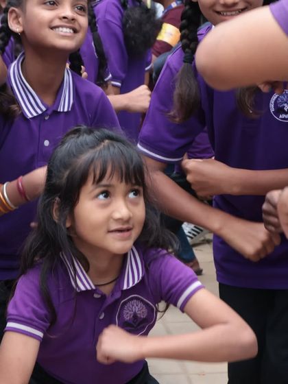 A moment of focus and fun. A young participant learns a new dance move at the Tandav festival, completely absorbed in the rhythm and the supportive atmosphere around her.