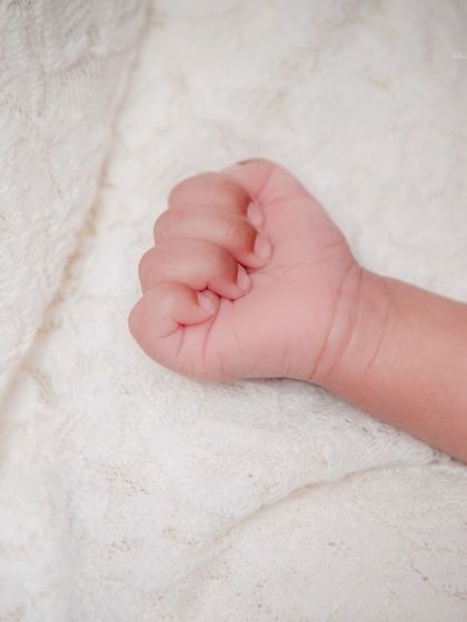 A tiny fist, full of dreams. This simple, clean shot focuses on the baby's hand, a small detail that holds so much love.