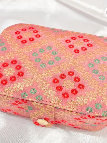 A rectangular jewelry box in a lovely pink bandhani-style fabric, perfect for storing small treasures.