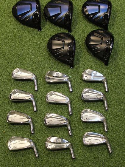 A collection of Honma driver heads and irons laid out, showcasing the variety available for fitting.