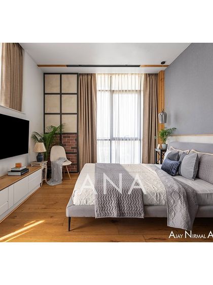 A full view of the master bedroom in Apartment 704, showcasing the balance of textures. The room features a wallpapered back wall, wooden flooring, and a raw brick side wall, creating a cozy and contemporary retreat.