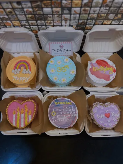 This is a sample of a 6-pack bento cake hamper, showing the variety of designs I can create. From hand-painted rainbows and flowers to custom calendar dates, each mini cake is a unique piece of edible art.
