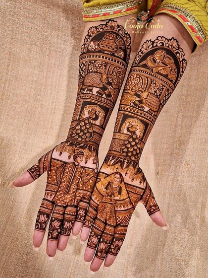 This bridal design features a unique combination of portraits and traditional motifs, including peacocks and elephants, creating a rich and varied look.