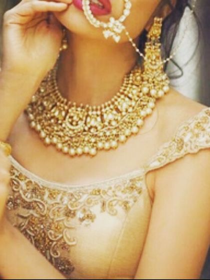 A close-up of a gold blouse with a sheer boat neck and intricate embroidery. The right neckline can make all the difference, and we help you choose what suits you best.