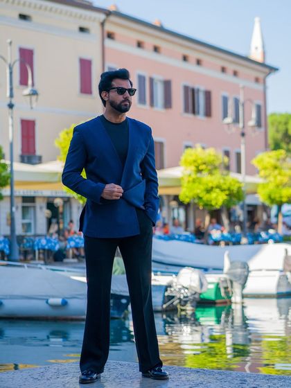 Posed by the water, the navy lapel-free blazer is a sophisticated choice for a seaside destination.
