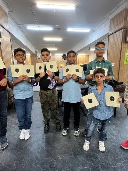 A group of young shooters proudly holding up their practice targets. It's great to see the next generation of marksmen getting started.