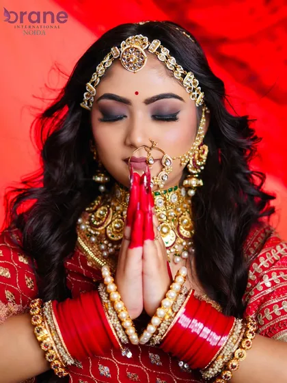 A prayer pose that showcases the alta-decorated hands and the rich, royal aesthetic of the entire look.