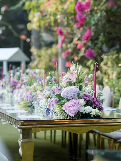 A closer look at a floral centerpiece for a corporate dinner. I use a mix of fresh flowers like lilies and hydrangeas with tall, elegant candles to add a touch of class to the table setting without obstructing conversation.