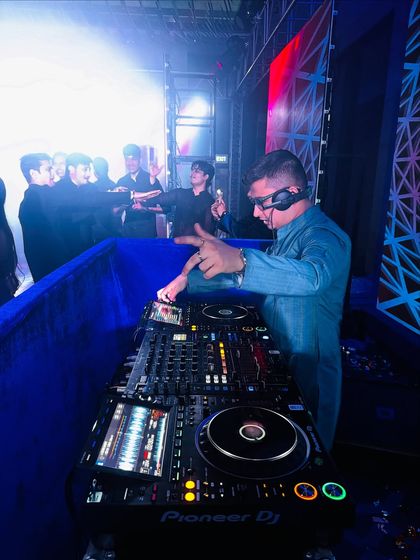 Focused on the mix during a high-energy wedding set. My goal is to create seamless transitions that keep the dance floor momentum going.