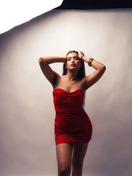 Using a single large light source to create a dramatic, sculpted look. The red dress pops against the neutral background.
