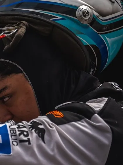 A close-up, artistic shot of a driver putting on his helmet.