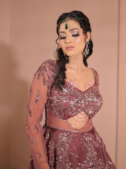 This image shows the full effect of the sequined mauve lehenga paired with sparkling eye makeup and a braided hairstyle, ideal for a sangeet or reception.