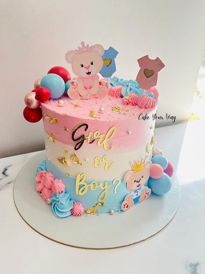 A sweet baby shower cake with pink and blue frosting, topped with cute teddy bears.