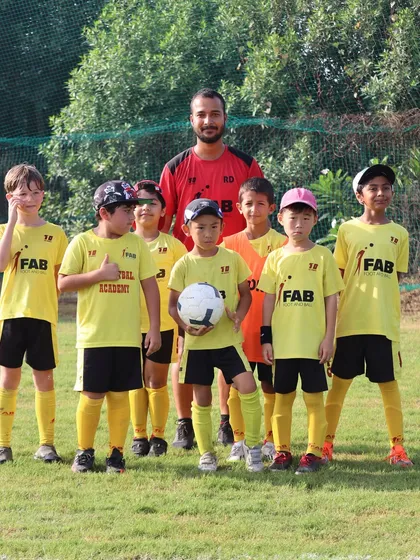 A coach with his team. Our holistic approach includes regular matches and training sessions to enhance skills and teamwork.