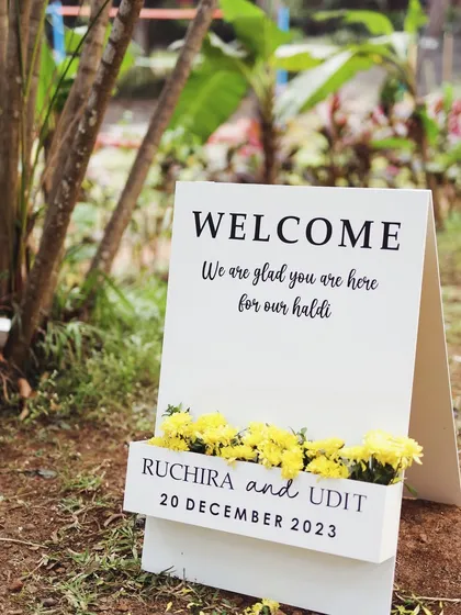 Another angle of the chic Haldi welcome sign, set against a natural, green backdrop. This minimalist design is perfect for a modern, understated celebration.