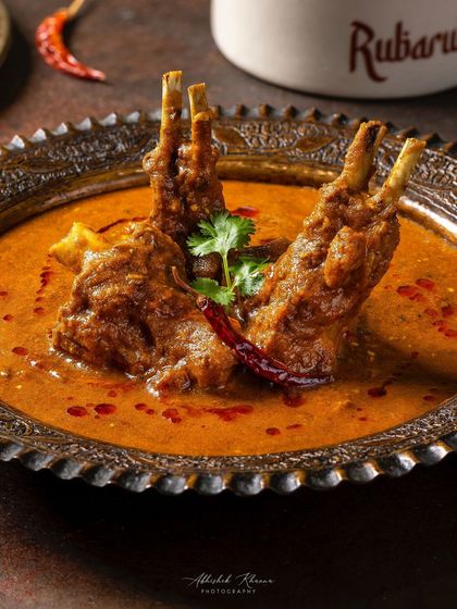 Mutton-e-Rubaruh, featuring tender mutton chops in a flavorful gravy. The composition for Rubaruh uses classic props to create an authentic, fine-dining atmosphere.