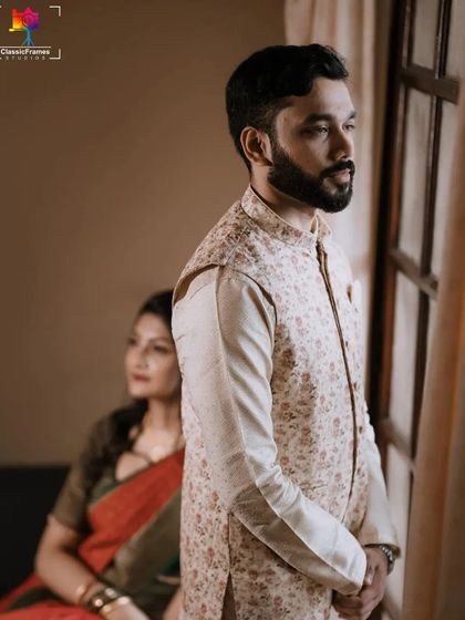 A quiet moment between the couple, captured with beautiful natural light from a window. The composition creates a feeling of intimacy and contemplation.