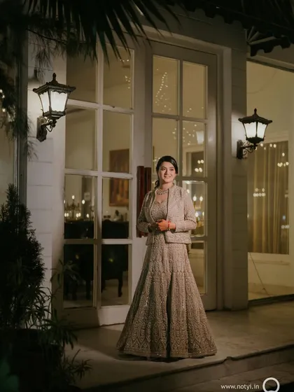 A full-length portrait from the sangeet night. The elegant gown is paired with a sophisticated updo and makeup that enhances her natural beauty.