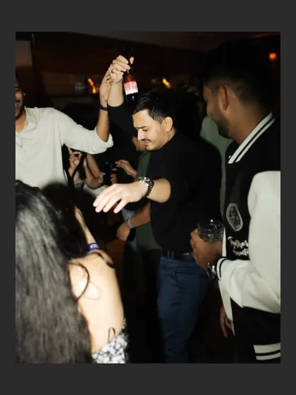 The groom enjoying himself on the dance floor during the cocktail party. A candid shot that captures the fun and relaxed atmosphere of the celebration.