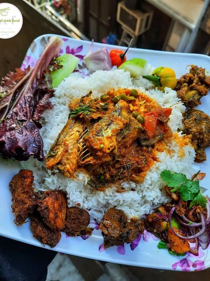 A beautiful platter featuring sea fish curry, fried chicken, and spicy chutney. A perfect meal for one.