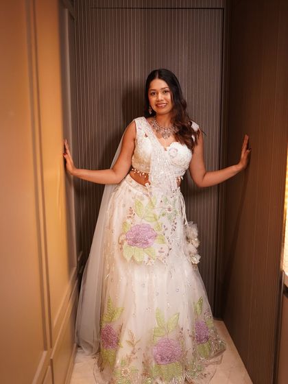 A full length view of this stunning white floral lehenga. The makeup is kept minimal to let the outfit and the bride's happiness shine.