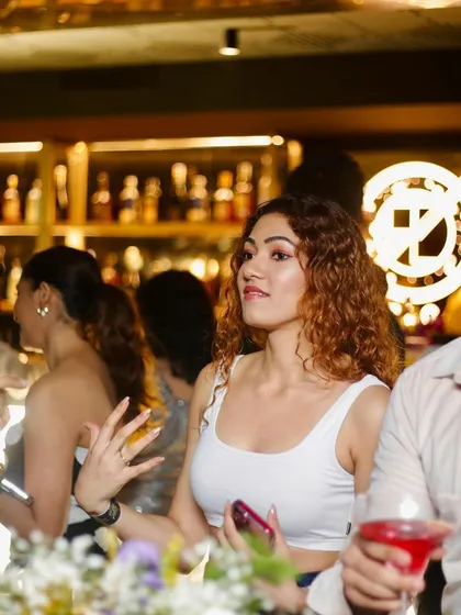 People mingling and enjoying drinks at the bar at Flo. It's not just about the dance floor, but the entire social experience.
