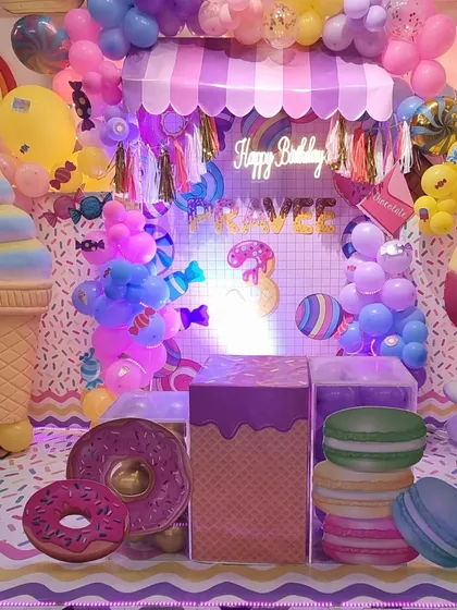 Another angle of our vibrant Candyland theme, showcasing the giant ice cream prop and custom neon "Happy Birthday" sign. We love making each party unique and memorable.