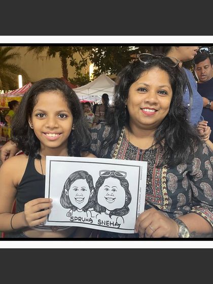 A mother and daughter duo with their caricature from an event in Ghatkopar. It's a wonderful keepsake for families.