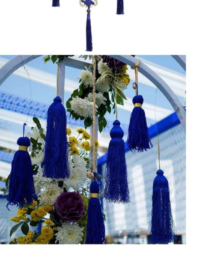 Blue tassels and floral arrangements used as hanging decor. These small, thematic details help tie the entire wedding look together.