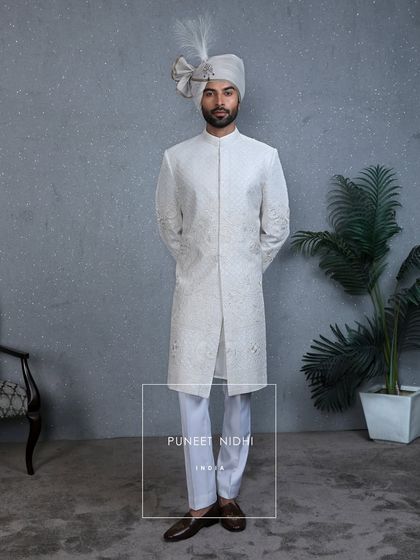 The classic ivory sherwani seen from the front, highlighting its clean, regal silhouette and the poise of royalty it imparts.