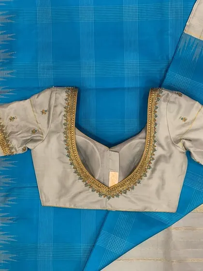 The front view of the grey embroidered blouse, showing the delicate V-neckline and sleeve details.