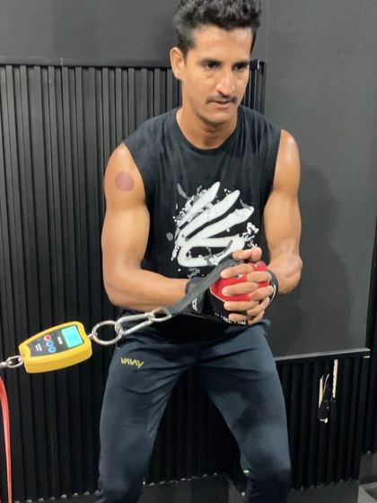 An athlete using a force gauge to measure rotational power during a cable pull, showcasing our data-driven approach to training.