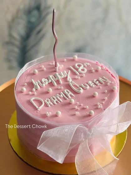A trendy pink cake wrapped in a clear collar and tied with a bow, for a modern, Pinterest-inspired look.