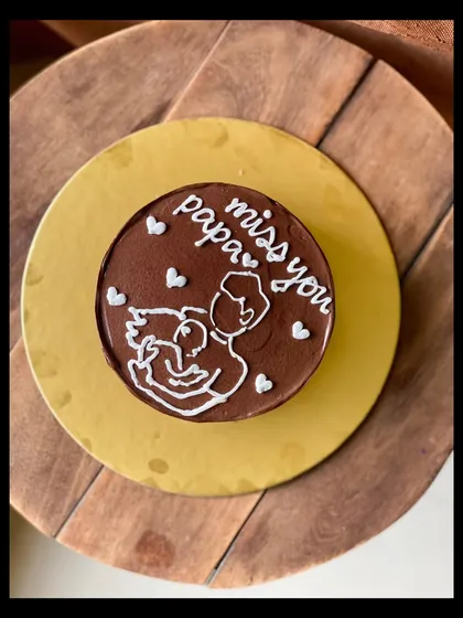 A touching and heartfelt cake with the message "miss you papa." The simple line drawing of a father and child makes this a deeply personal and meaningful cake.
