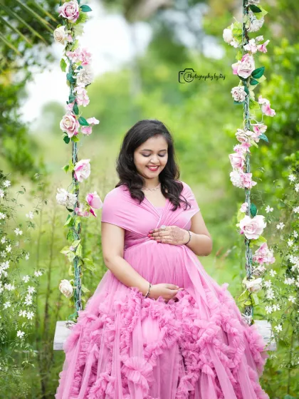 A serene moment on our floral swing. The mother-to-be looks beautiful in a pink ruffled gown.