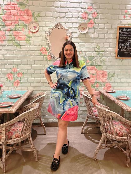 The new Rose Cafe location is stunning. I chose this spot to take a photo because the floral wall and vintage furniture perfectly reflect the cafe's charming and cozy vibe.