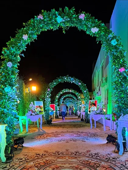 A clear view of the enchanted garden walkway, showing the beautiful green arches and the personalized photo displays on either side.